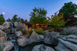 Experience tranquility in this stunning property featuring a serene waterfall cascading over natural rock formations.
