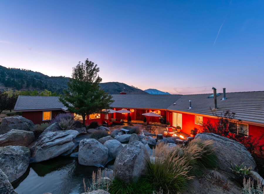 Experience luxury living in this stunning property featuring a beautiful red exterior and a serene outdoor oasis.