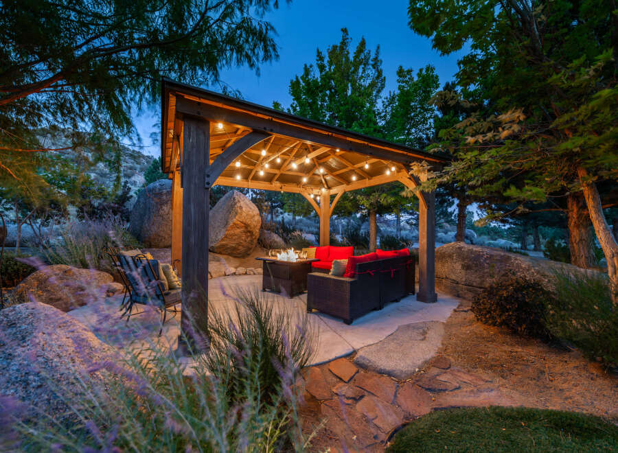 Experience luxury living in this stunning outdoor oasis! This property features a beautifully designed gazebo with string lights, perfect for evening gatherings.