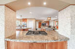 Step into this stunning kitchen, showcasing a beautiful granite countertop and a modern gas cooktop.