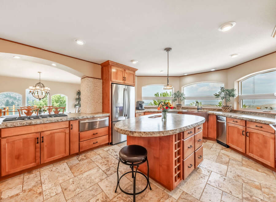 This stunning kitchen boasts a spacious layout with beautiful wooden cabinetry and granite countertops, perfect for both cooking and entertaining.