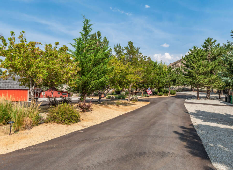 Discover the charm of this stunning property, featuring a winding asphalt driveway that leads to a picturesque setting.