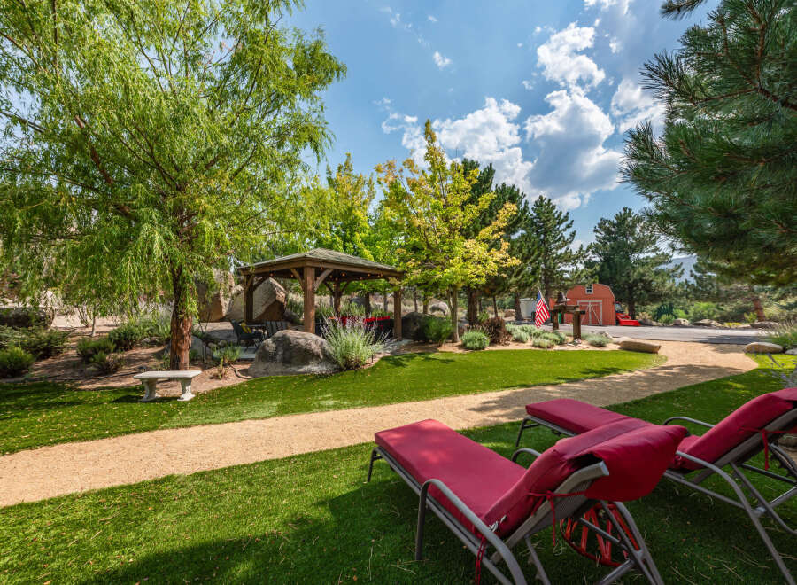 Enjoy the tranquility of this stunning property featuring lush green lawns and a charming gazebo, perfect for outdoor relaxation.