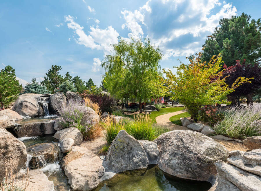 Discover a serene oasis in this stunning property, featuring a beautifully designed water feature with cascading waterfalls and natural rock formations.