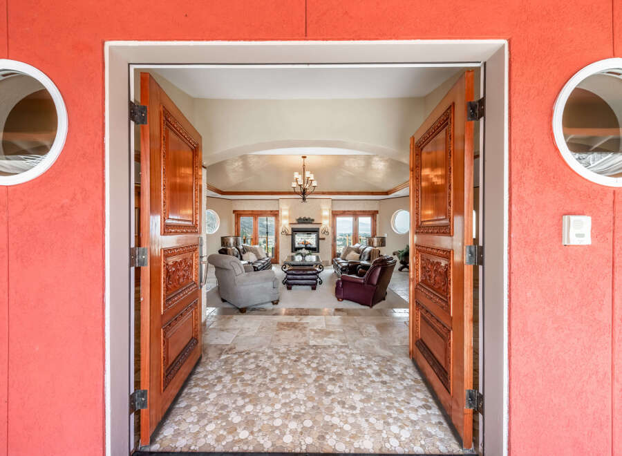 Step into luxury with this stunning property! The grand entrance features exquisite wooden doors that open to reveal a spacious living area.