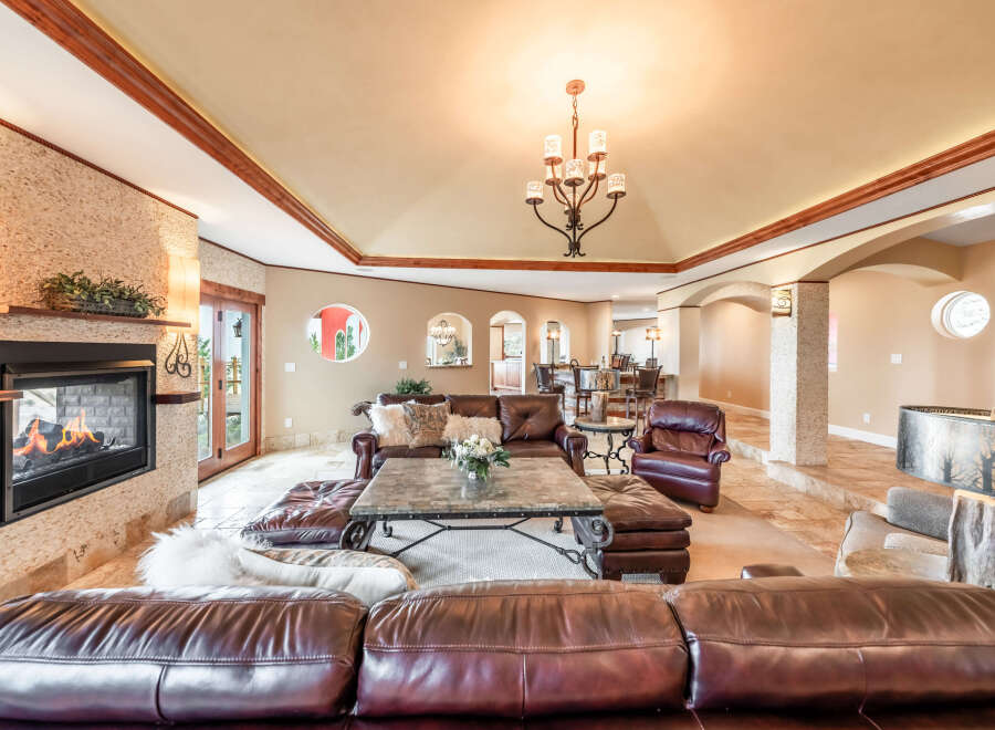 Step into luxury with this stunning living room, featuring a cozy fireplace and elegant leather seating.