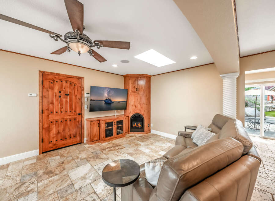 This stunning property boasts a cozy living room with a fireplace and a large-screen TV, perfect for relaxing evenings.