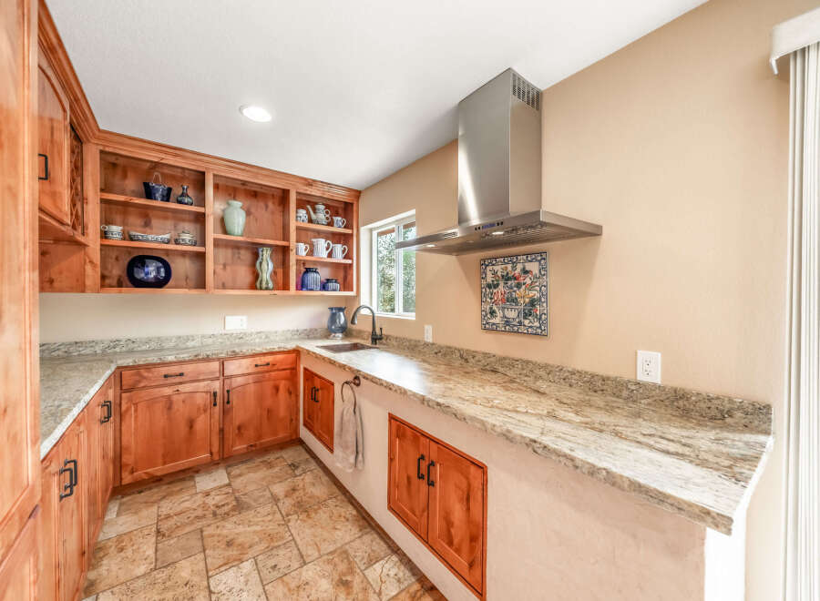 This stunning kitchen boasts custom wooden cabinetry and granite countertops, offering both style and functionality.