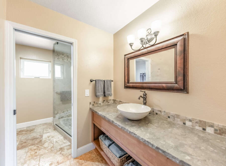 This beautiful bathroom features a stylish vanity with a vessel sink and a large mirror.