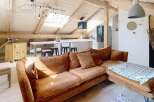 Discover the charm of this stunning property, featuring a spacious living area with a cozy brown sofa and a modern kitchen.