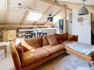 Discover the charm of this stunning property, featuring a spacious living area with a cozy brown sofa and a modern kitchen.