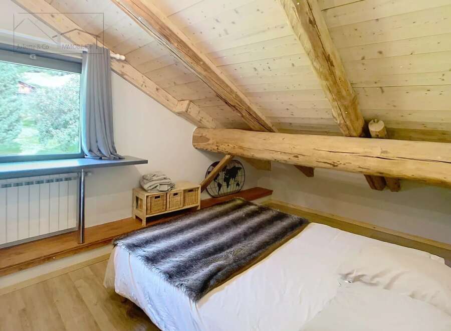 Discover the charm of this cozy bedroom, featuring a unique wooden beam ceiling that adds character and warmth.