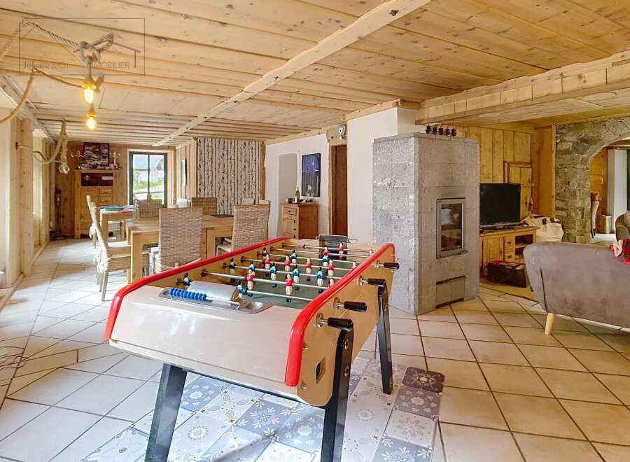 Discover this charming property featuring a cozy living space with a foosball table, perfect for entertainment.