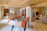 Discover this charming property featuring a cozy living space with a foosball table, perfect for entertainment.