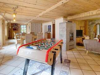 Discover this charming property featuring a cozy living space with a foosball table, perfect for entertainment.