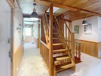 Discover the charm of this inviting property, featuring a beautifully crafted wooden staircase that adds character and warmth.