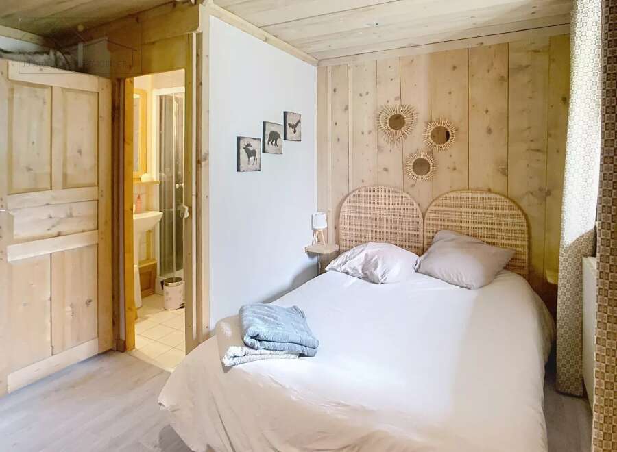 Discover the charm of this cozy bedroom, featuring a rustic wooden headboard and walls that exude warmth.
