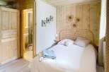 Discover the charm of this cozy bedroom, featuring a rustic wooden headboard and walls that exude warmth.