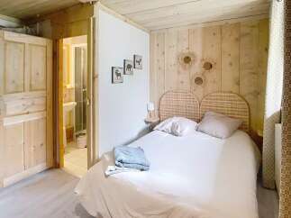 Discover the charm of this cozy bedroom, featuring a rustic wooden headboard and walls that exude warmth.