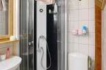 Discover this charming bathroom featuring a modern shower cabin and a convenient toilet setup.
