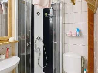 Discover this charming bathroom featuring a modern shower cabin and a convenient toilet setup.