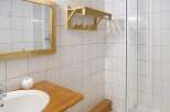 This bathroom features a sleek, modern design with a wooden vanity and a spacious shower.