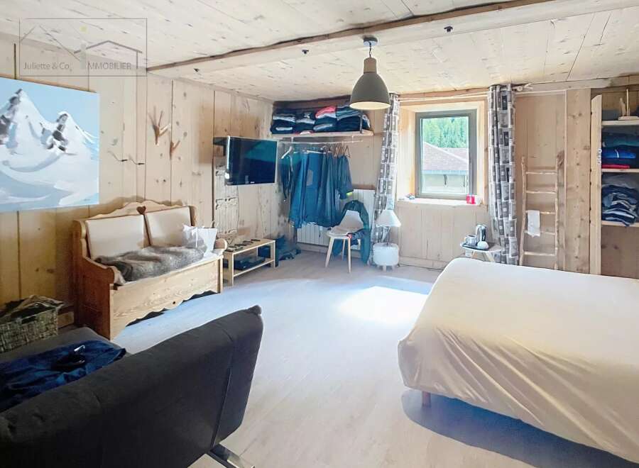 Discover the charm of this cozy bedroom, featuring rustic wooden paneling and a warm, inviting atmosphere.