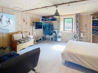 Discover the charm of this cozy bedroom, featuring rustic wooden paneling and a warm, inviting atmosphere.