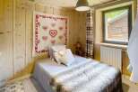 Cozy bedroom with wooden walls and ceiling, creating a warm and inviting atmosphere.