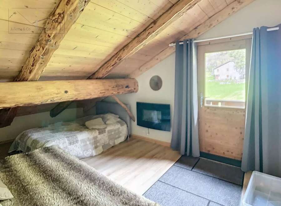 Discover the charm of this cozy attic retreat, featuring exposed wooden beams and a rustic aesthetic.