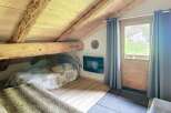 Discover the charm of this cozy attic retreat, featuring exposed wooden beams and a rustic aesthetic.