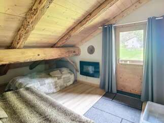 Discover the charm of this cozy attic retreat, featuring exposed wooden beams and a rustic aesthetic.