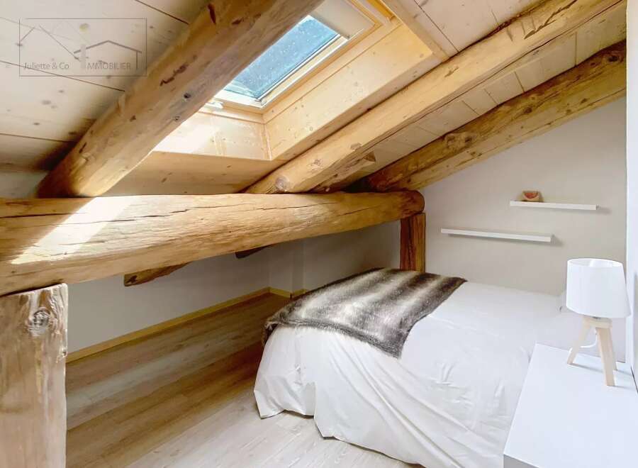 Discover the charm of this cozy bedroom, featuring exposed wooden beams that add character and warmth.
