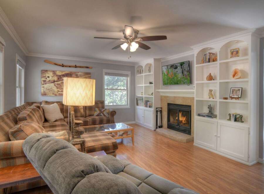 Step into luxury with this stunning living room, featuring a cozy fireplace and built-in shelving.