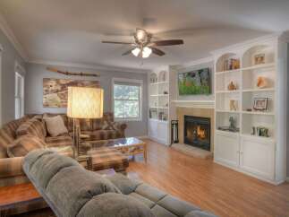 Step into luxury with this stunning living room, featuring a cozy fireplace and built-in shelving.