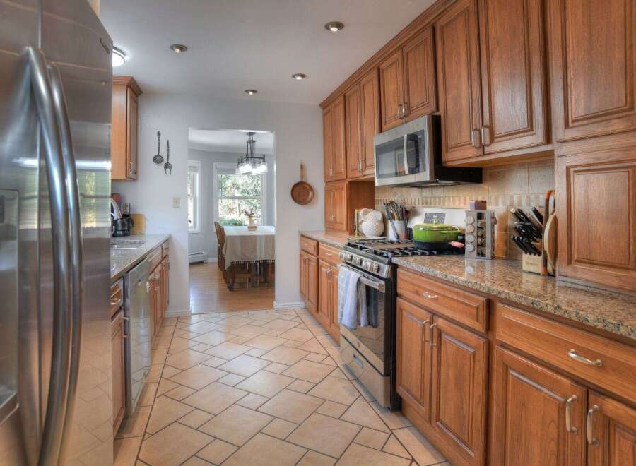 Step into this inviting kitchen, featuring warm wooden cabinetry and sleek stainless steel appliances.