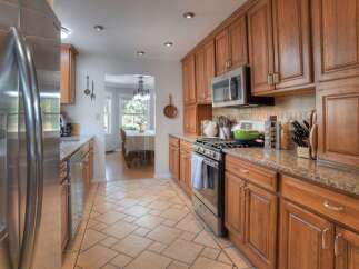 Step into this inviting kitchen, featuring warm wooden cabinetry and sleek stainless steel appliances.