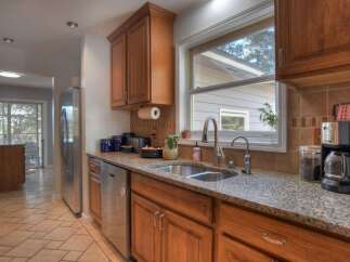 This beautiful kitchen boasts stunning granite countertops and warm wooden cabinetry, creating an inviting and functional space.
