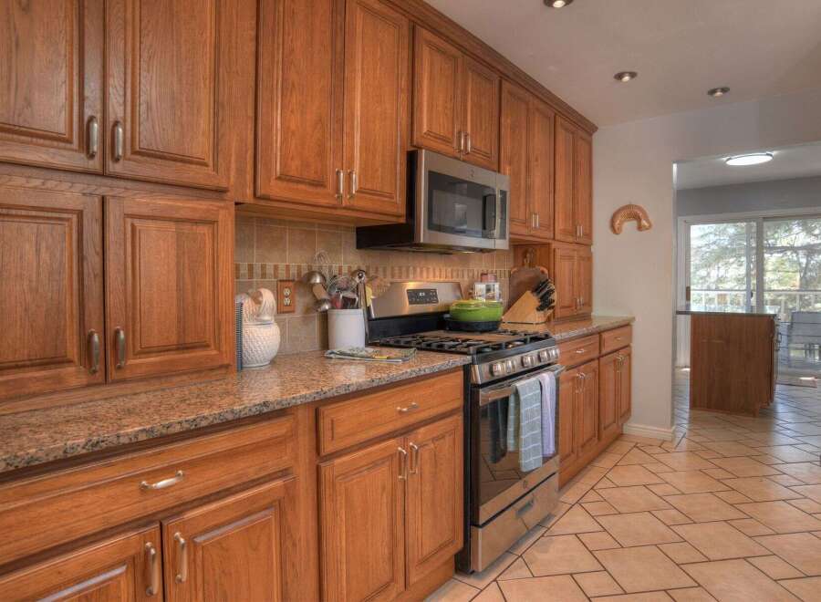 This beautiful kitchen boasts custom cabinetry, offering ample storage and a warm, inviting atmosphere.