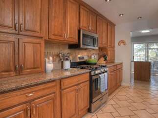 This beautiful kitchen boasts custom cabinetry, offering ample storage and a warm, inviting atmosphere.