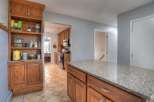 Step into this inviting kitchen, featuring warm wooden cabinetry and a spacious granite countertop island.