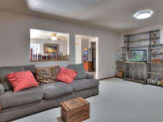 This inviting living space features a cozy gray sofa adorned with decorative pillows, perfect for relaxation.