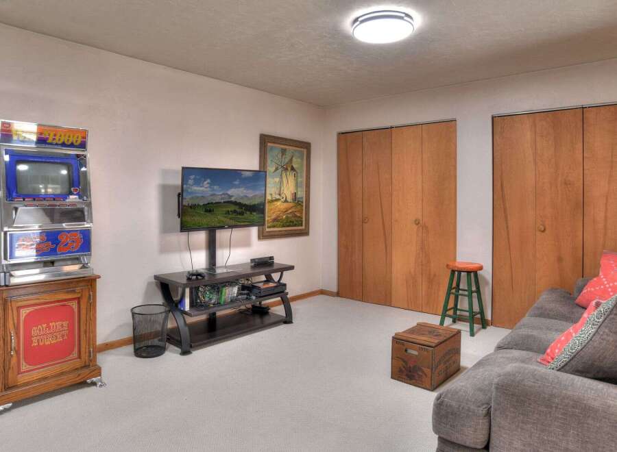 This cozy living space features a unique vintage slot machine, adding a touch of retro charm.