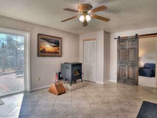 Step into this inviting living space, featuring a cozy fireplace and a rustic sliding barn door.