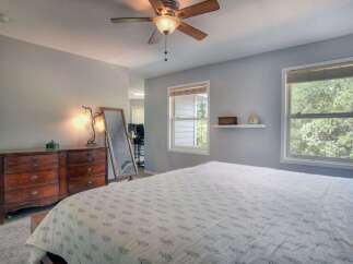 This inviting bedroom offers a serene retreat with its soft color palette and ample natural light.