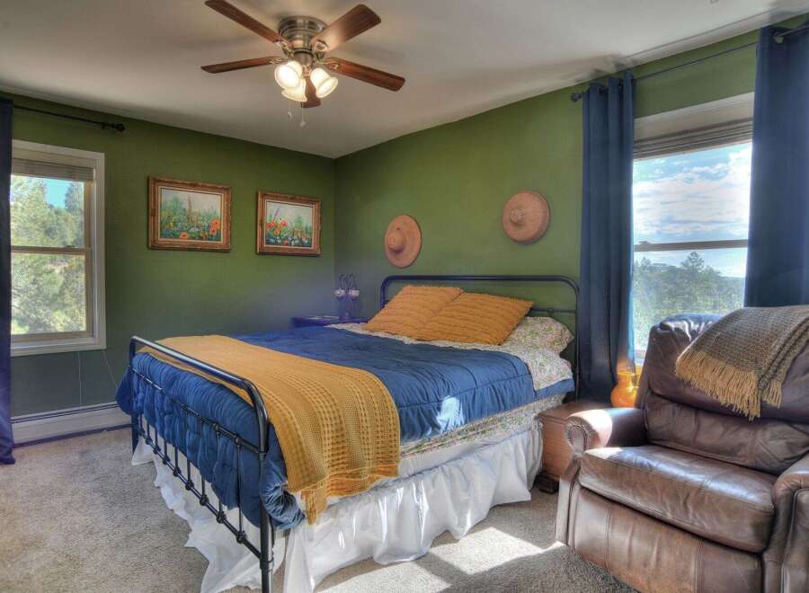 This cozy bedroom features a comfortable bed with a vibrant blue comforter and a warm yellow throw, creating a welcoming atmosphere.