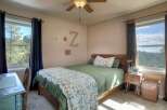 This cozy bedroom features a comfortable bed with a floral quilt, perfect for a relaxing retreat.