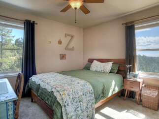 This cozy bedroom features a comfortable bed with a floral quilt, perfect for a relaxing retreat.