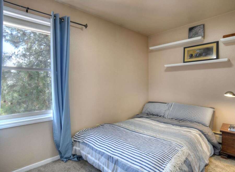 This cozy bedroom features a comfortable bed with a stylish striped comforter, perfect for a relaxing retreat.