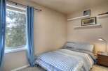 This cozy bedroom features a comfortable bed with a stylish striped comforter, perfect for a relaxing retreat.